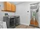Bright laundry room featuring modern washer and dryer, upper cabinets and wood-look flooring at 1202 Marshall Ct, Eustis, FL 32726