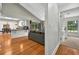 View of the living room flowing into kitchen, featuring hardwood floors and large windows at 1202 Marshall Ct, Eustis, FL 32726