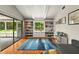 Bright living room with a large window, built-in bookshelves, and sliding glass doors leading to a patio at 1202 Marshall Ct, Eustis, FL 32726