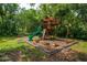 A backyard playground features a slide, climbing wall, swings and lookout tower, surrounded by mature trees at 1202 Marshall Ct, Eustis, FL 32726