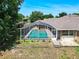 An aerial view captures the backyard oasis featuring a screened pool, complemented by lush landscaping at 1233 Gladstone Dr, Deltona, FL 32725