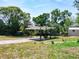 Backyard features a pergola, complemented by green lawns and vibrant plants at 1233 Gladstone Dr, Deltona, FL 32725
