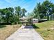 A shaded backyard pergola, accessible via a concrete path, offers a serene outdoor space at 1233 Gladstone Dr, Deltona, FL 32725