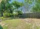 Backyard showing a wood fence, some green grass, a few trees and otherwise dirt and some weeds at 1233 Gladstone Dr, Deltona, FL 32725