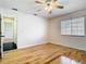 Bright bedroom featuring hardwood floors and a ceiling fan with a large window at 1233 Gladstone Dr, Deltona, FL 32725