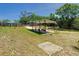 Backyard carport structure with wood posts and a light colored corrugated metal roof, grass surrounds at 1233 Gladstone Dr, Deltona, FL 32725