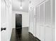 Hallway featuring glossy floors, white trim, a dark front door, and coat closet at 1233 Gladstone Dr, Deltona, FL 32725