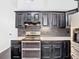 Well-lit kitchen showcasing modern stainless steel appliances and dark, stylish cabinetry at 1233 Gladstone Dr, Deltona, FL 32725