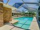 Screened-in pool area with a brick exterior and clear blue water at 1233 Gladstone Dr, Deltona, FL 32725