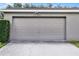 Attached two-car garage with a concrete driveway and manicured landscaping at 12335 Cruxbury Dr, Windermere, FL 34786