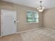Inviting living area featuring neutral tones, plush carpet, and a bright window offering natural light at 12335 Cruxbury Dr, Windermere, FL 34786