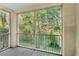 Screened-in balcony with a peaceful view of the surrounding trees and greenery at 12837 Madison Pointe Cir # 206, Orlando, FL 32821