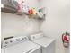Well-equipped laundry room with a washer, a dryer, a fire extinguisher, and shelving at 12837 Madison Pointe Cir # 206, Orlando, FL 32821