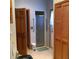 This bathroom features several wooden doors, a glass-enclosed shower, and tile flooring throughout the space at 13111 Sunshine Cir, Clermont, FL 34711