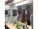 Bright bathroom featuring a long vanity, large mirrors, and storage cabinets with a laundry hamper at 13111 Sunshine Cir, Clermont, FL 34711