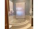 The bathroom features a large, tiled corner bathtub with tiled steps up to it, plus decorative window coverings at 13111 Sunshine Cir, Clermont, FL 34711