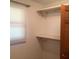 Closet featuring white shelving, wooden doors, and a window with blinds at 13111 Sunshine Cir, Clermont, FL 34711