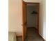 Walk in closet with a carpeted floor, open wooden door, and black hangers at 13111 Sunshine Cir, Clermont, FL 34711