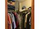 Organized closet with hanging clothes and shelves for luggage, storage boxes, and other belongings at 13111 Sunshine Cir, Clermont, FL 34711