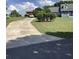 Long driveway leading to a well-maintained blue home with lush landscaping at 13111 Sunshine Cir, Clermont, FL 34711