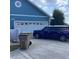 Home exterior with a blue finish, featuring a two-car garage and a well-maintained driveway at 13111 Sunshine Cir, Clermont, FL 34711
