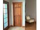 Hallway featuring a wooden door, tile floors, and a glimpse of a cozy seating area at 13111 Sunshine Cir, Clermont, FL 34711
