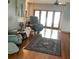 Bright living room area with hardwood floors, a comfortable recliner, and access to the porch at 13111 Sunshine Cir, Clermont, FL 34711