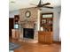 Cozy living room featuring a brick fireplace, built-in bookshelves, and hardwood floors at 13111 Sunshine Cir, Clermont, FL 34711