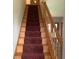 Elegant staircase with wooden railing and burgundy carpet runner, enhancing the home's interior charm at 13111 Sunshine Cir, Clermont, FL 34711