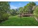 Expansive backyard featuring lush lawn and a charming wooden deck surrounded by trees at 1389 Gainesville Ln, Deltona, FL 32725