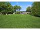 Expansive backyard features a well-maintained lawn, deck, and mature trees at 1389 Gainesville Ln, Deltona, FL 32725