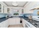 A cozy kitchen featuring white cabinets, blue countertops, and a window overlooking a leafy view at 1389 Gainesville Ln, Deltona, FL 32725