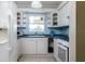 A cozy kitchen featuring white cabinets, blue countertops, and a window overlooking a leafy view at 1389 Gainesville Ln, Deltona, FL 32725