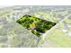 Aerial view of the property showcasing the home, lush greenery, and expansive land at 1391 Terry Ln, Kissimmee, FL 34744