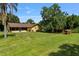 Expansive backyard featuring a screened porch, mature trees, and plenty of space for outdoor activities and entertaining at 1391 Terry Ln, Kissimmee, FL 34744