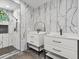 Modern bathroom with marble tile, double vanities, and a tiled walk-in shower at 1391 Terry Ln, Kissimmee, FL 34744