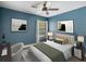 Comfortable blue bedroom with natural light, sleek furniture, stylish decor, and a ceiling fan at 1391 Terry Ln, Kissimmee, FL 34744