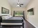 Bright bedroom featuring hardwood floors, a ceiling fan, and a large window with a view at 1391 Terry Ln, Kissimmee, FL 34744