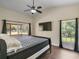 Bright bedroom with a king bed, tiled floors, and large windows offering serene views of the surrounding greenery at 1391 Terry Ln, Kissimmee, FL 34744