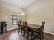 Dining room featuring a wooden table, four chairs, and a pendant light fixture at 1391 Terry Ln, Kissimmee, FL 34744