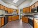 Bright kitchen featuring wood cabinets, a skylight, stainless steel appliances, and tile floors at 1391 Terry Ln, Kissimmee, FL 34744