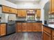 Traditional kitchen featuring wood cabinets, dark countertops, and stainless steel appliances at 1391 Terry Ln, Kissimmee, FL 34744