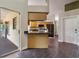 Open-concept kitchen with wood cabinets, dark countertops, modern appliances, and a breakfast bar at 1391 Terry Ln, Kissimmee, FL 34744