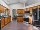 Well-equipped kitchen with wood cabinets, dark countertops, stainless steel appliances, and tiled floors at 1391 Terry Ln, Kissimmee, FL 34744