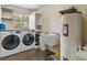 Functional laundry room with washer, dryer, utility sink, and storage shelves for convenience at 1391 Terry Ln, Kissimmee, FL 34744