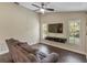 Relaxing living room with a modern TV setup, tiled floors, and natural light, ideal for entertainment at 1391 Terry Ln, Kissimmee, FL 34744