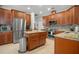 Kitchen with granite countertops, stainless appliances, wood cabinets, and a center island with drawers at 14131 Islamorada Dr, Orlando, FL 32837