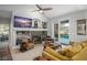 Living room featuring a fireplace, built-in shelving, a ceiling fan, and tile flooring at 14131 Islamorada Dr, Orlando, FL 32837
