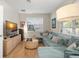 Comfortable living room boasts a soft blue sectional, modern decor, and wood flooring for a cozy feel at 14131 Islamorada Dr, Orlando, FL 32837