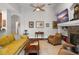 Living room with tile flooring, neutral paint, ceiling fan, built in shelving, and tan leather furniture at 14131 Islamorada Dr, Orlando, FL 32837